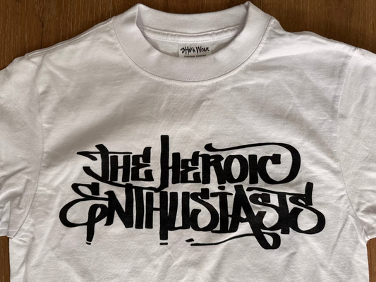 White t-shirt with black text "The Heroic Enthusiasts"