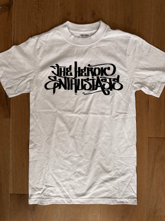 White t-shirt with black text "The Heroic Enthusiasts"